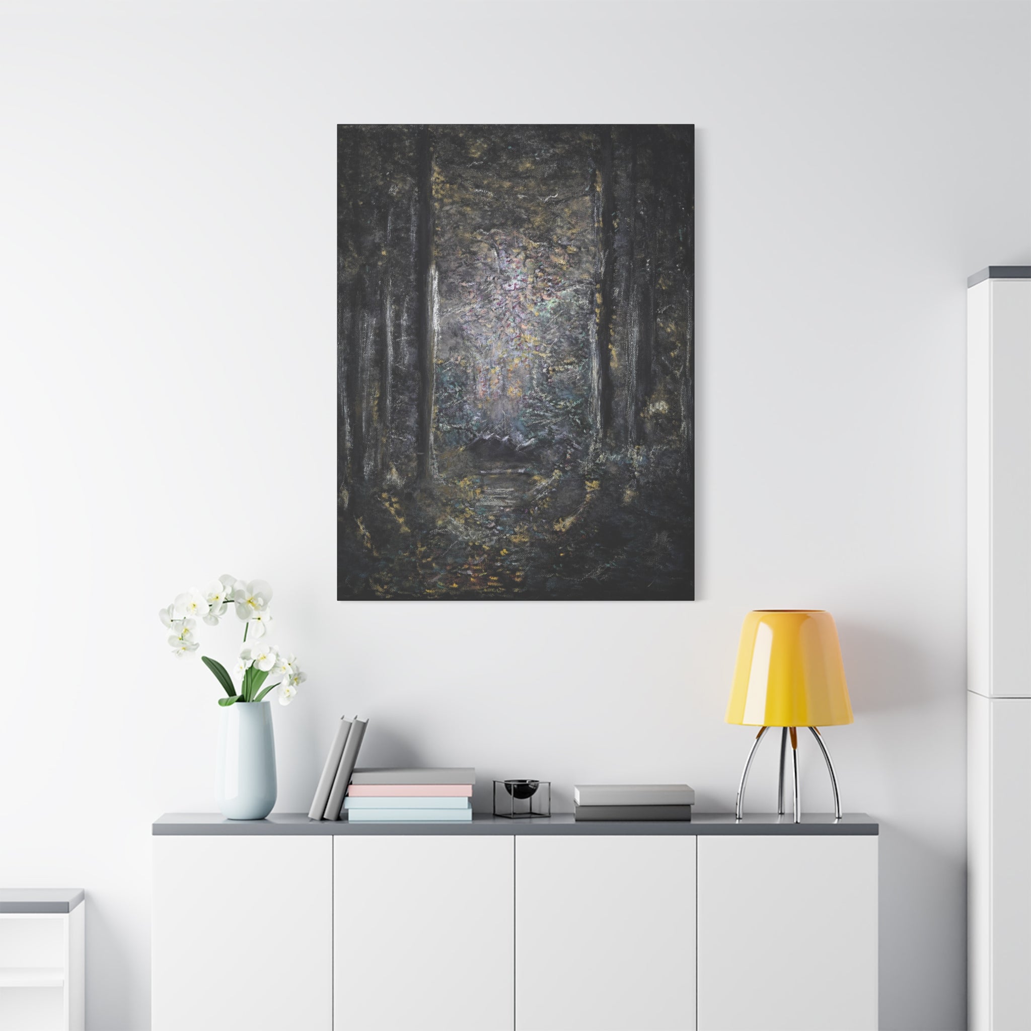 Canvas printed after original artwork of a forest scene on a white wall above a shelf with decor items.