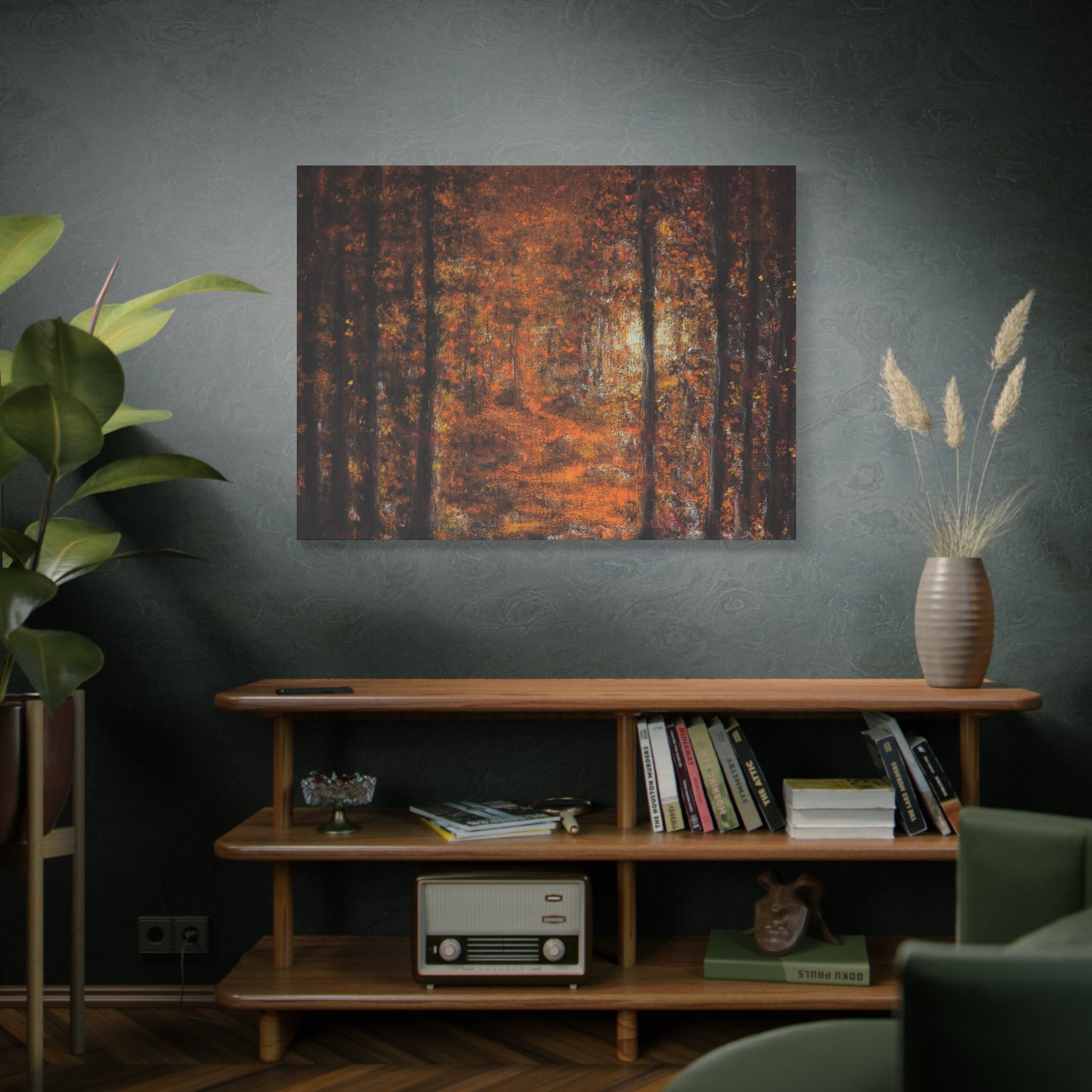 Livingroom interior with an Autumn Forest Path Matte Canvas Wall Art of a forest scene in brown, orange and yellow tones on the wall above a wooden shelf.