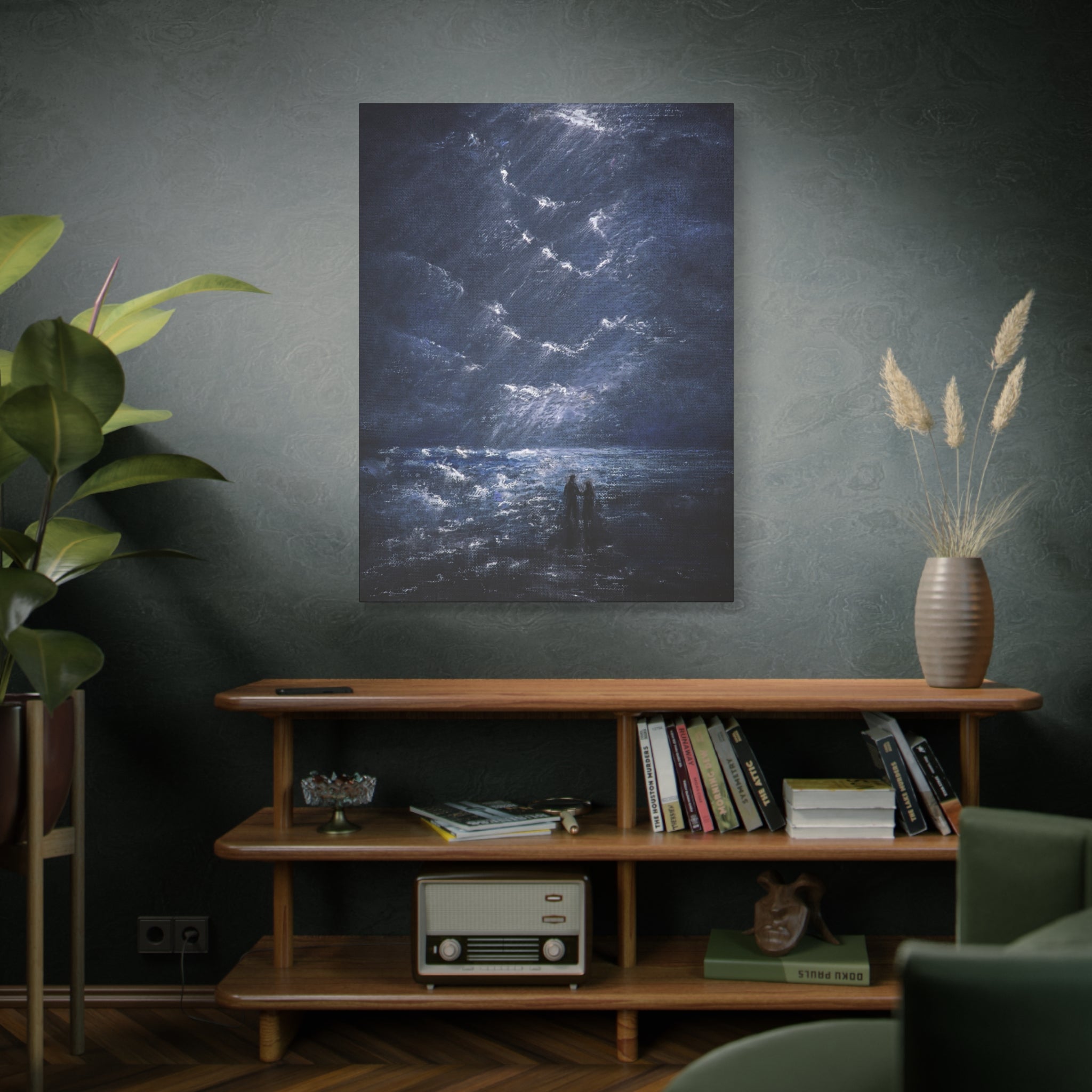 Room interior with a canvas of a couple walking on shore, a wooden shelf with books and decor, and a plant.