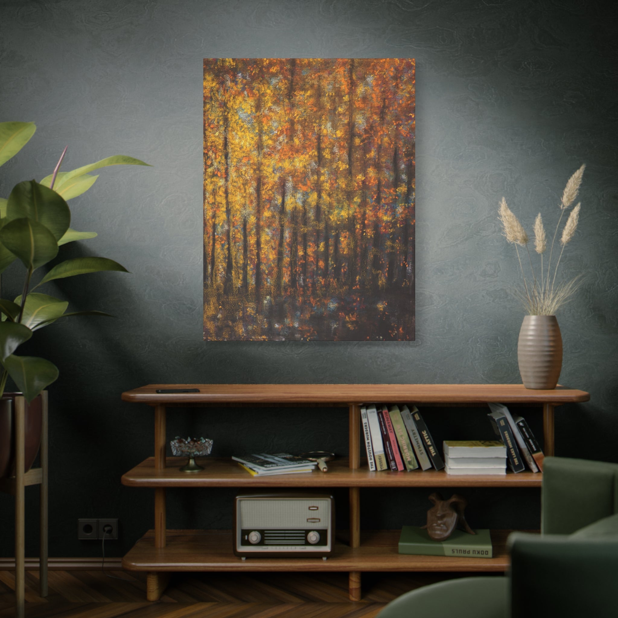Living room with a wooden shelf, books, a plant, and an Autumn Forest Matte Canvas Wall Art – Golden Fall Trees on the wall in orange, yellow and brown tones.